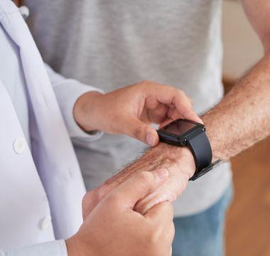 Doctor looking at a patient's movement-tracking device on his wrist