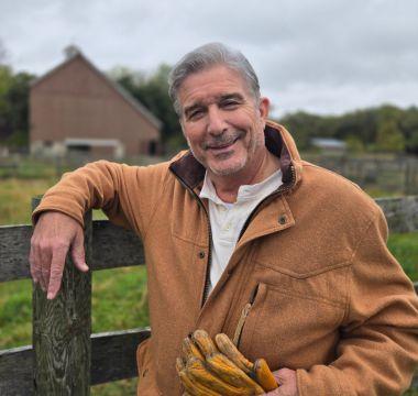 Bob Baittie standing against a fence