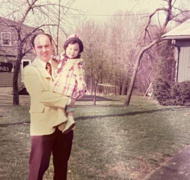 Christine's dad holding a baby