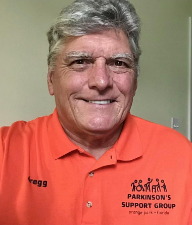 Gregg Hummer smiling wearing a Parkinson's Support Group polo