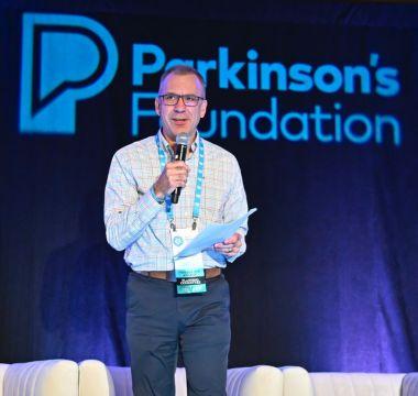 John speaking on stage at a Parkinson's Foundation conference