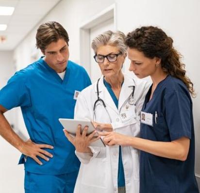 Group of medical professionals looking at an ipad