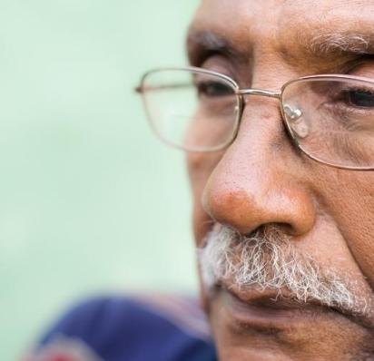 Close-up of man wearing glasses staring into distance with serious expression