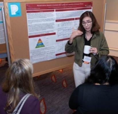 Healthcare professional in front of a scientific poster lecturing to students