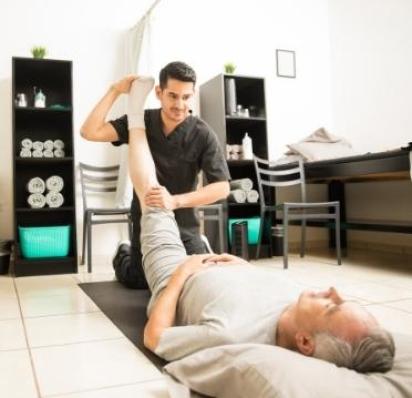 Physical therapist helping patient stretch leg