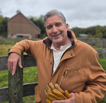 Bob Baittie standing against a fence