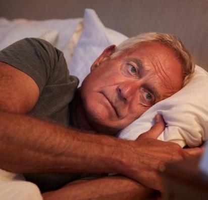 Man laying in bed with eyes open