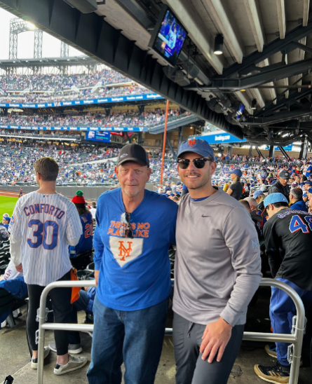 (left to right) Jack Ryan's dad and Jack Ryan posing for a picture at a baseball game.