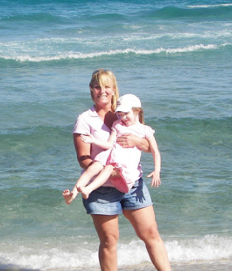 Kelly Maurer holding daughter at beach