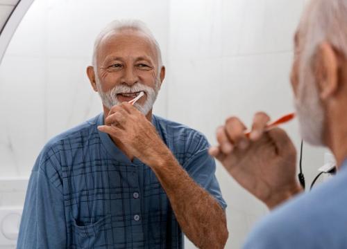 Older man brushing his teeth