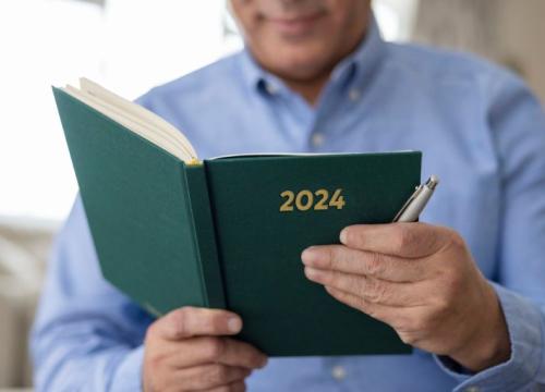 Man holding a book that says 2024