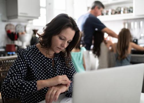 Woman working from home with family in the background