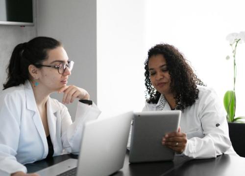 Two female researchers looking at a laptop and tablet