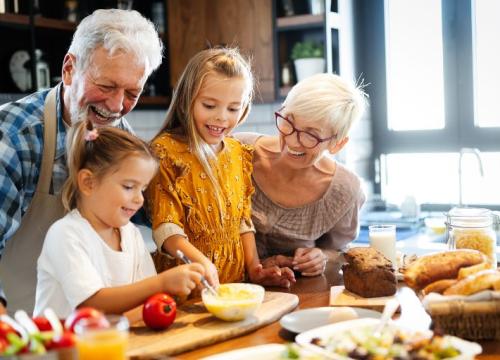 Grandparents with granddaughters cooking in kitchen