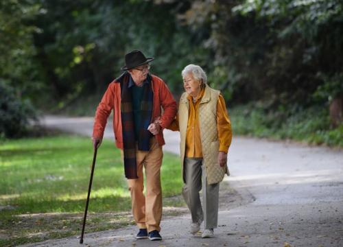 Older couple walking through a park