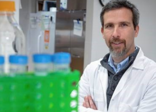 Male scientist posing in lab by vials