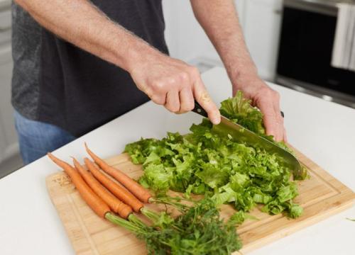 Man cutting lettuce and carrots 