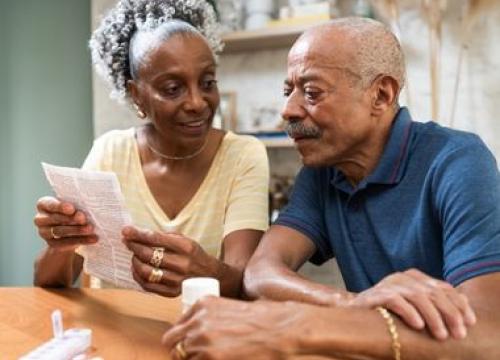 Couple sitting at the table reviewing medication paperwork