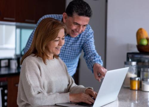 pareja mirando una computadora portátil
