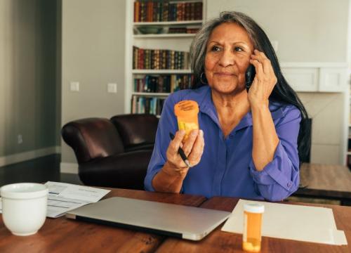 Woman talking on the phone, holding a pill bottle