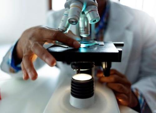 Researcher looking at a sample through a microscope