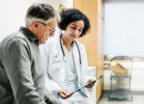 Nurse sitting with patient going over paperwork
