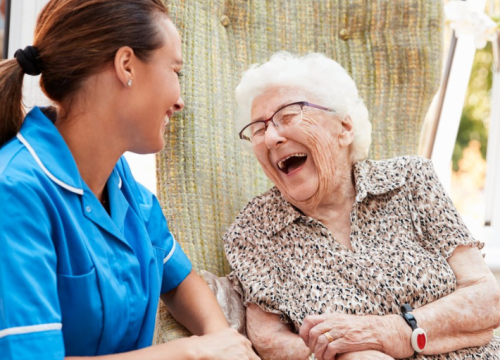 Older woman laughing with a nurse