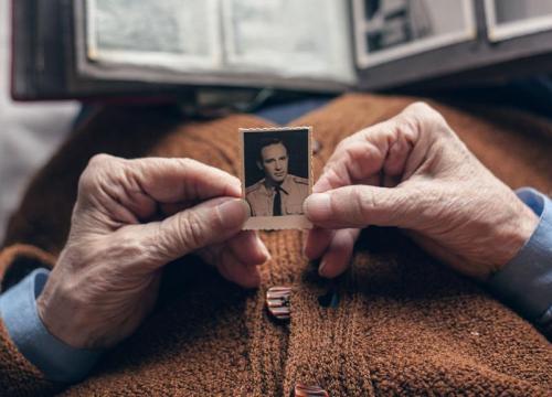 Older person holding a photograph of a young man