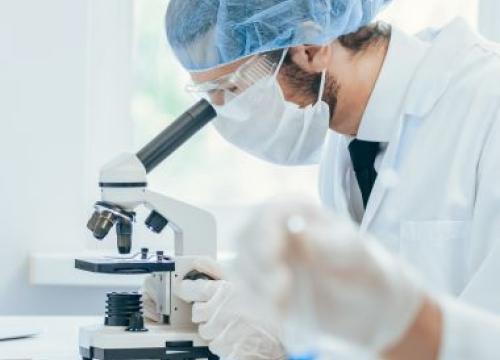 Lab tech looking through microscope