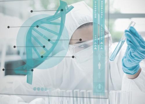 Researcher in lab looking at vial