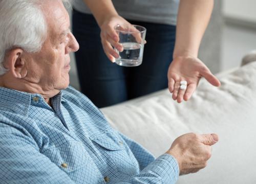 giving medications to older man