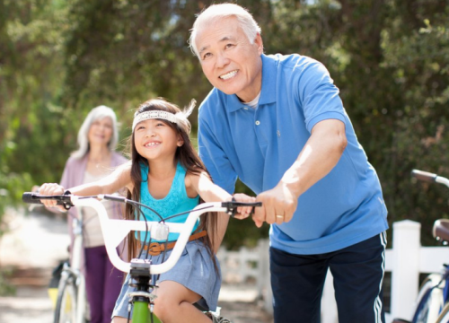 grandparent helping grandchild ride bike