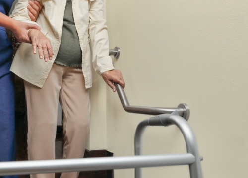 Nurse assisting someone with a walker