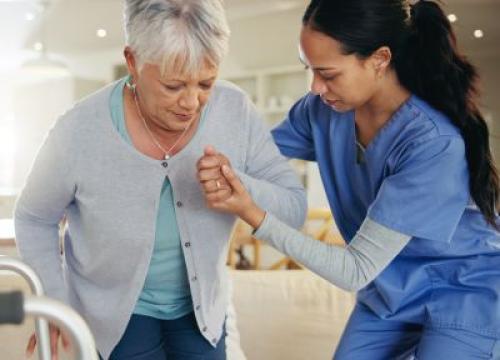 Nurse helping senior woman stand