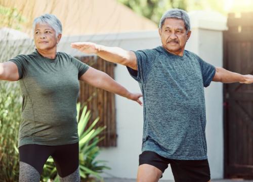 Pareja de personas mayores estirando al aire libre