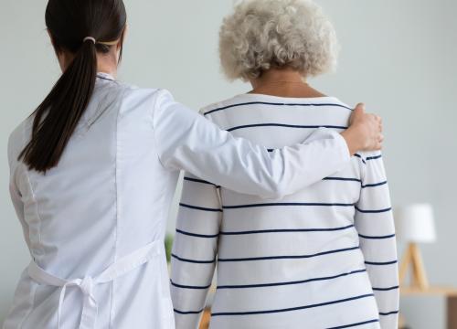 Doctor supporting an older woman