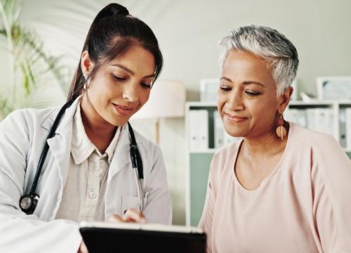 Doctor and senior woman looking at tablet together