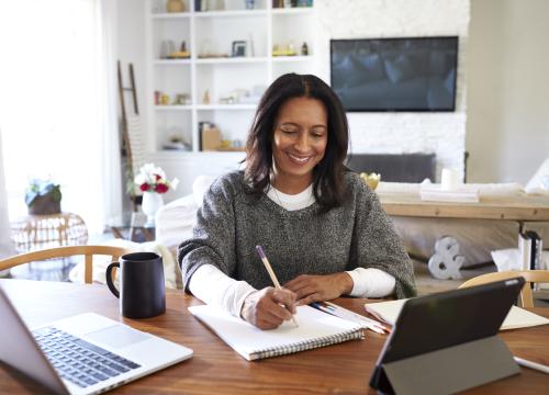 Woman writing notes at her desk