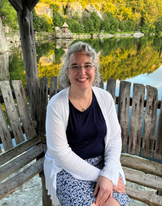 Liz Brouillard sitting on a bench posing for a picture.