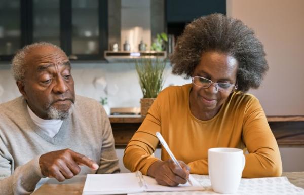 Wife taking notes while husband assists