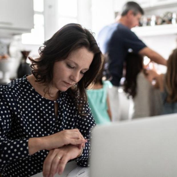 Woman working from home with family in the background