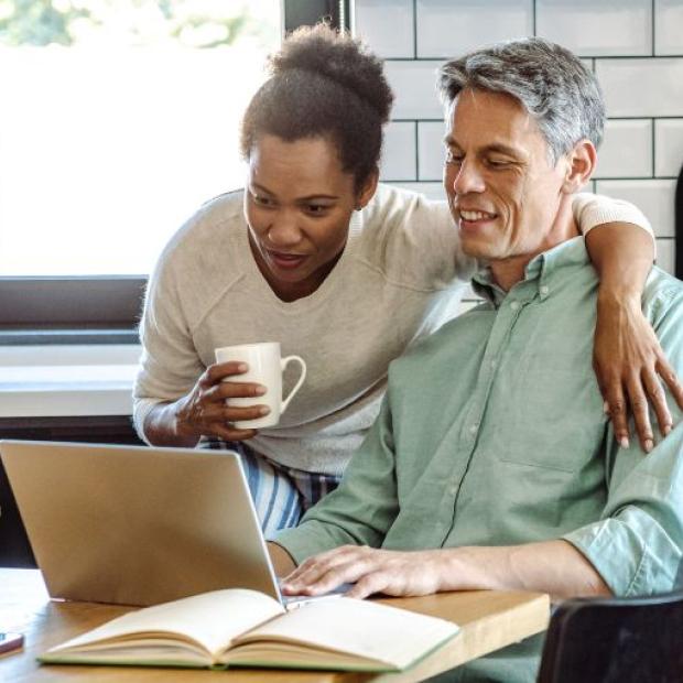 Couple looking at laptop at the kitchen table