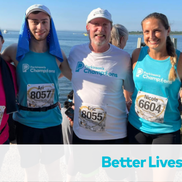 An image of a family smiling at the camera after a Champion's event by the beach.