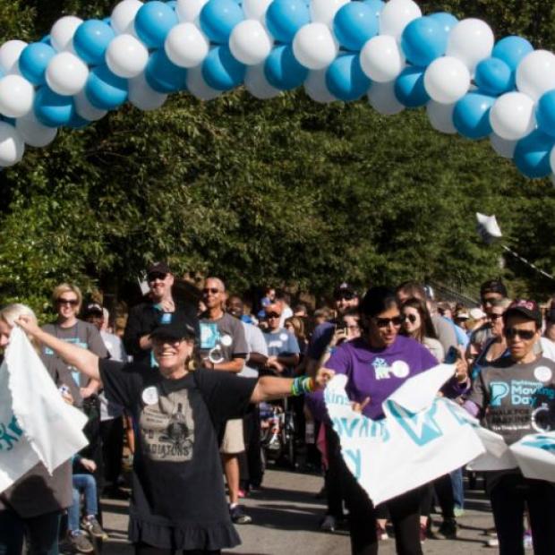 Group of people going through the finish line at a Moving Day Walk