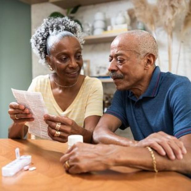 Couple sitting at the table reviewing medication paperwork