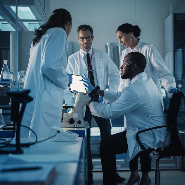 Group of researchers looking at tablet in lab