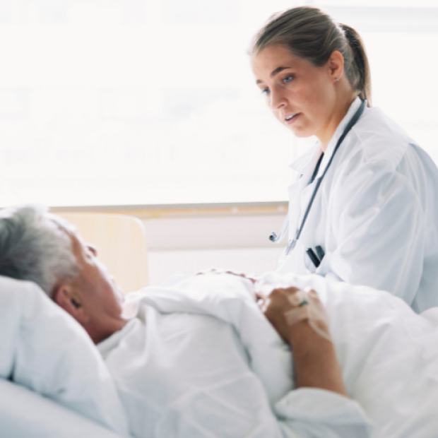 Female doctor talking to hospital patient in bed