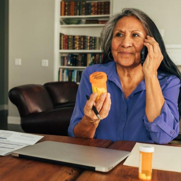 Woman talking on the phone, holding a pill bottle