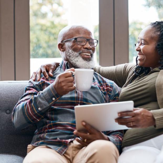 Husband and wife drinking coffee on couch