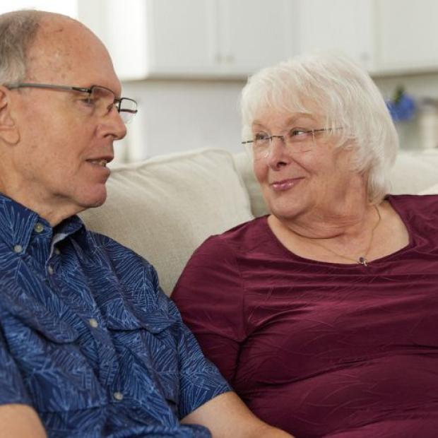 Couple sitting on the couch smiling at each other